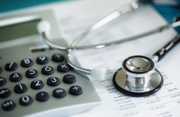 Calculator and stethoscope on financial statement concept for finance health check or cost of healthcare